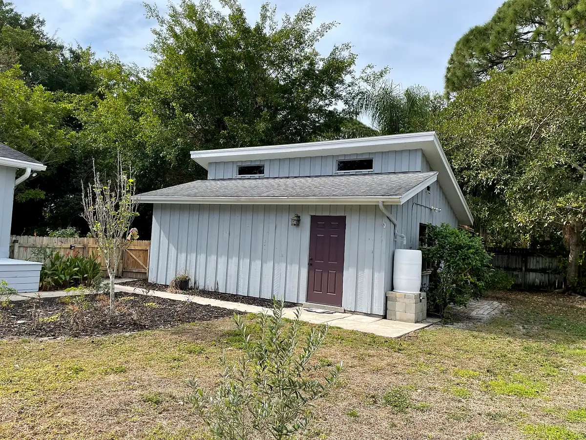 Backyard shed surrounded by open lawn before planting, Bradenton 2024