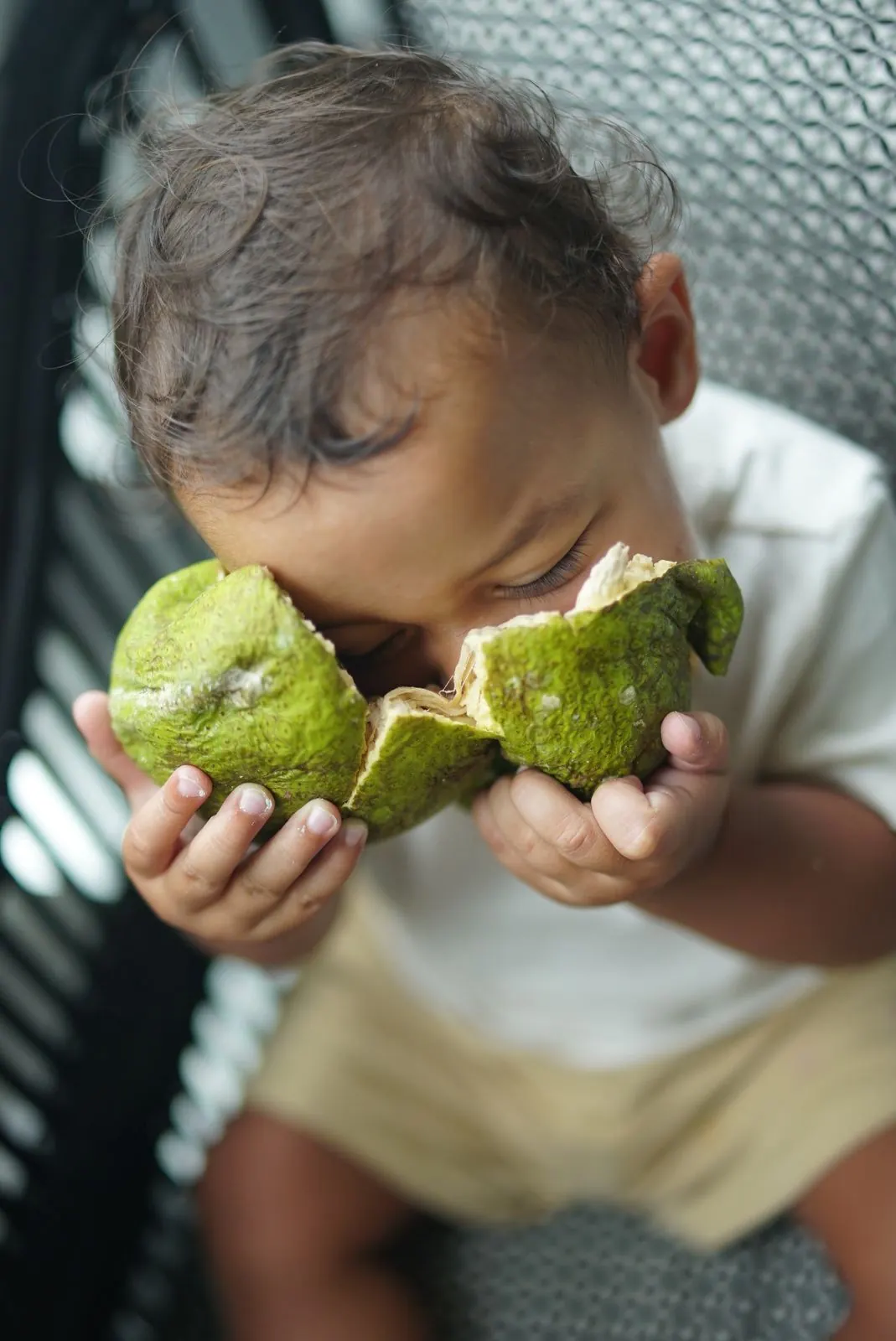 Matthew's baby tasting a freshly opened breadfruit