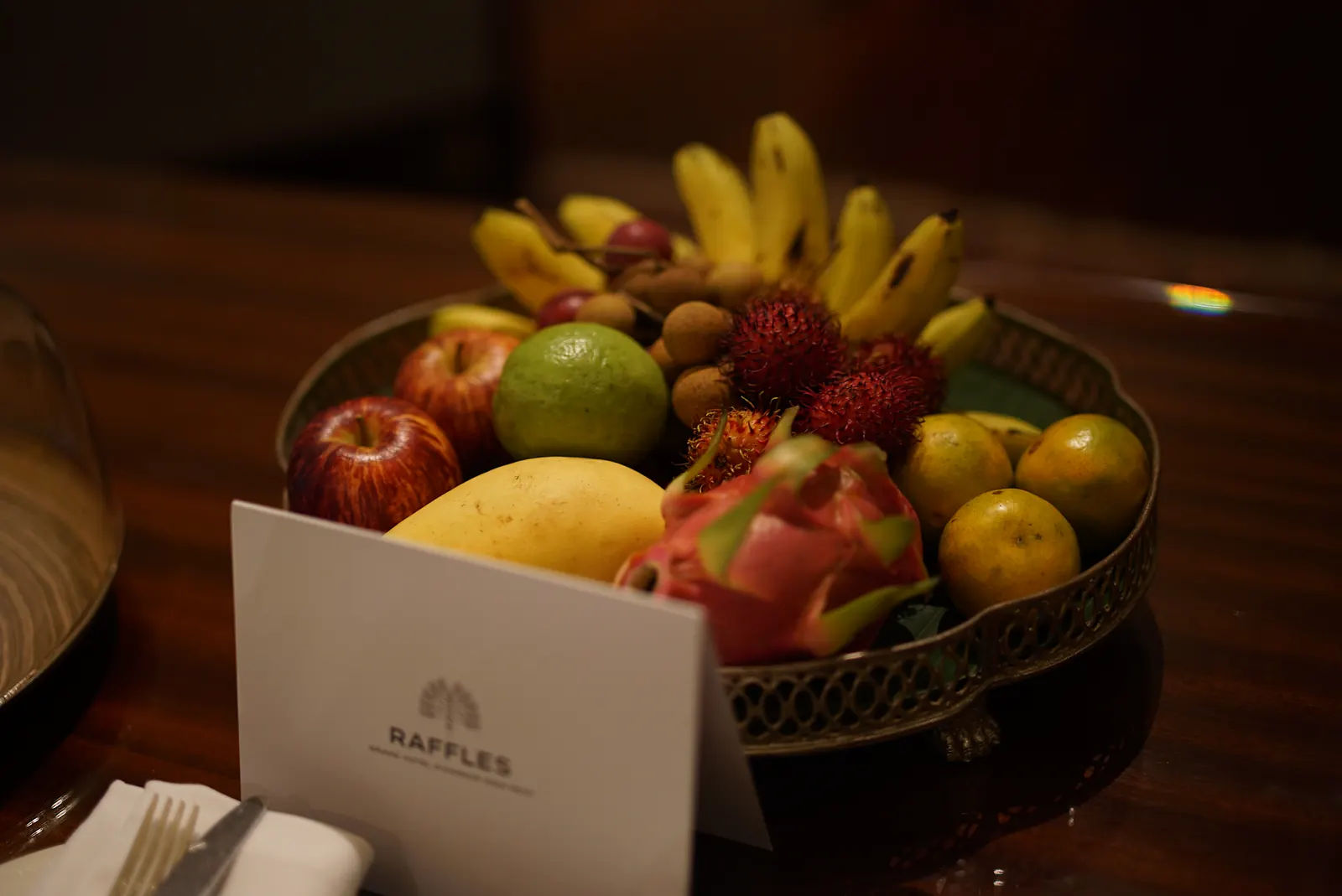 A basket of tropical fruit with dragon fruit, mango, bananas and rambutan