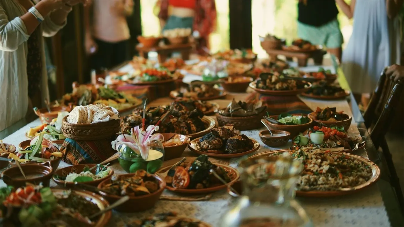 A long communal table set with garden-grown dishes at a harvest feast