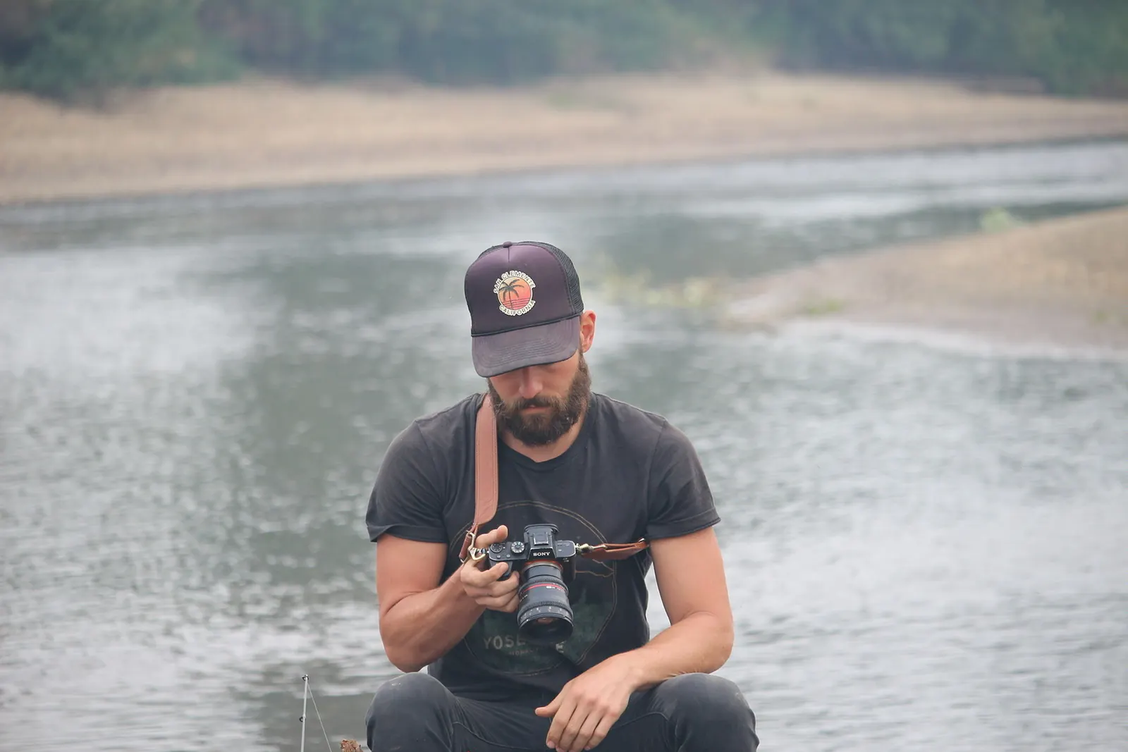 Matthew Nadu crouched by a river with his camera