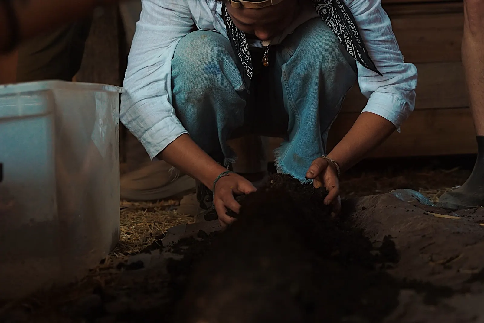 Hands working dark, rich soil in the field
