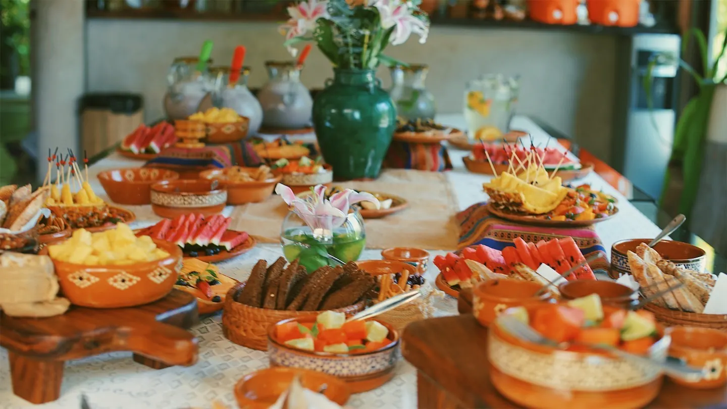 A colorful table spread of tropical fruit and dishes on a fruit-hunting trip