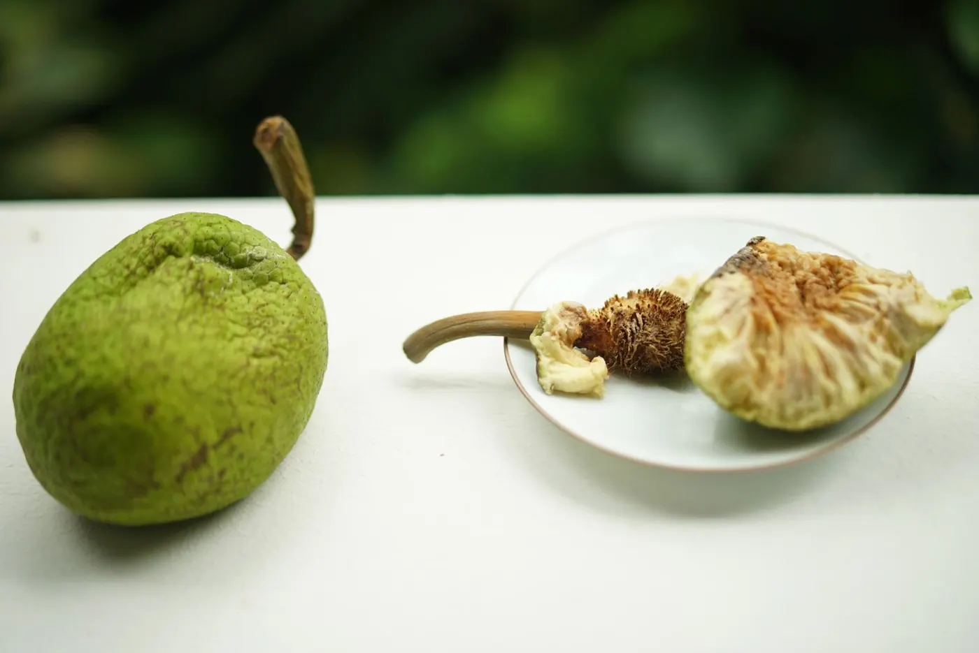 A rare tropical fruit, whole and opened, on a table